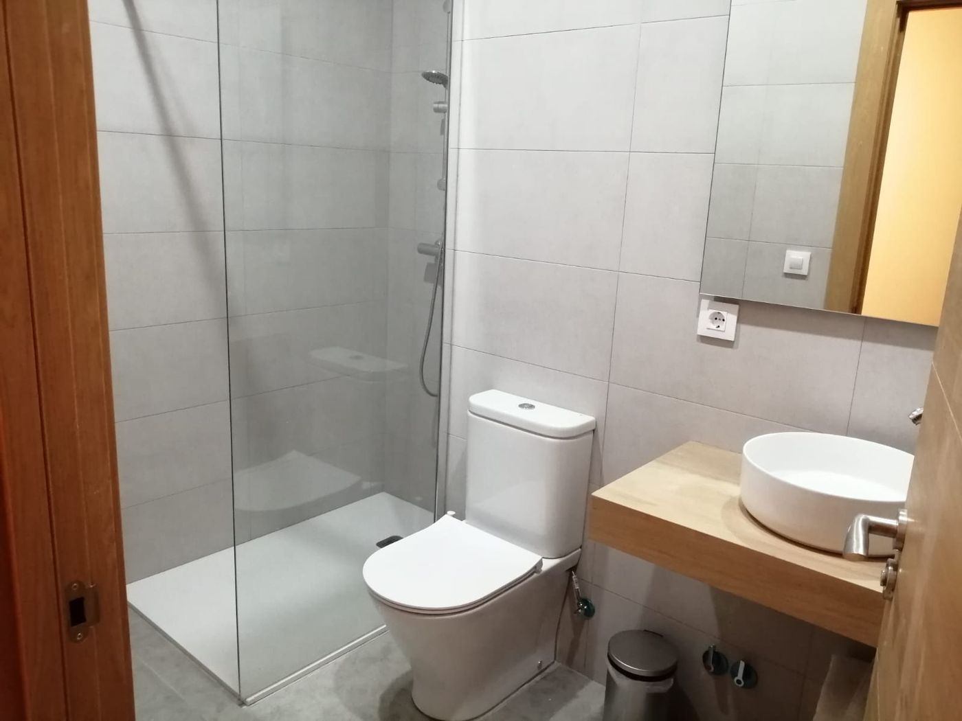 Baño en suite de Lastoetxe, con ducha de cristal y lavabo sobre encimera de madera