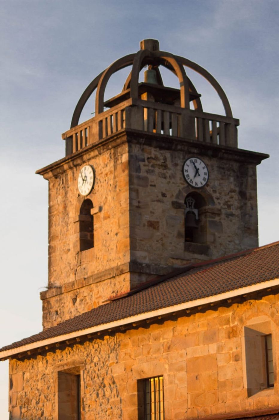 Campanario de piedra a contraluz dorado, cerca de Lastoetxe en Meñaka