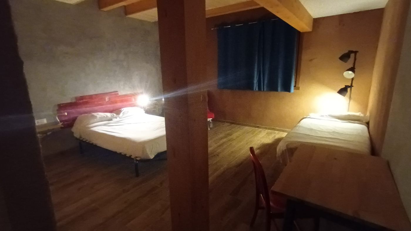 Habitación Mattin en Lastoetxe, con dos camas separadas por una columna de madera vista