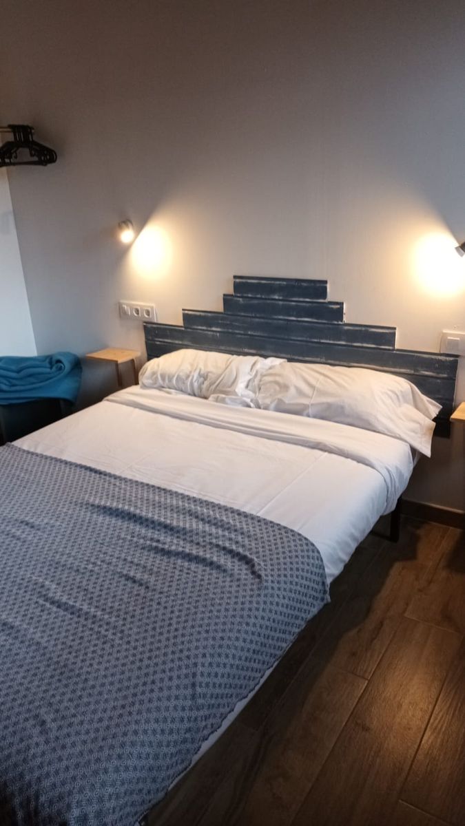 Habitación Irati en Lastoetxe, con cabecero rojo y vigas de madera vista